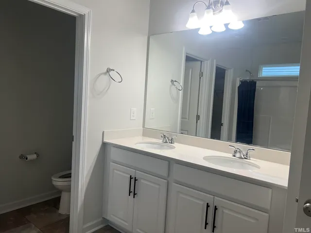 a bathroom with a granite countertop sink a toilet and a mirror