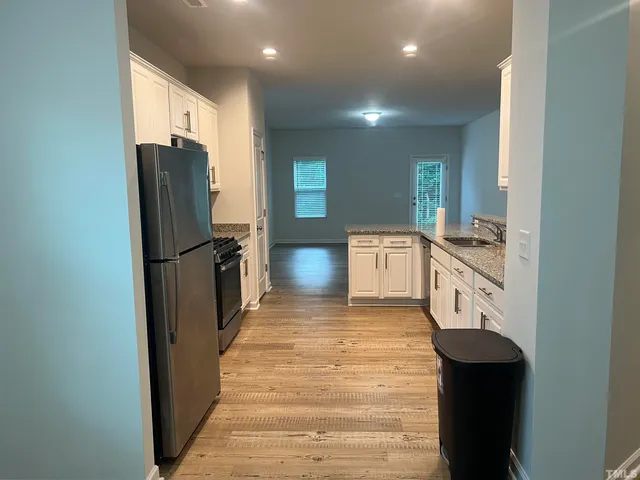 a kitchen with stainless steel appliances granite countertop a refrigerator and a sink