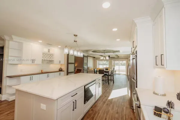 a kitchen with a refrigerator a sink and wooden floor