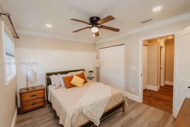 a bedroom with a bed a flat screen tv and a chandelier