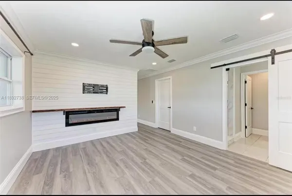 a view of a room with wooden floor and ceiling fan