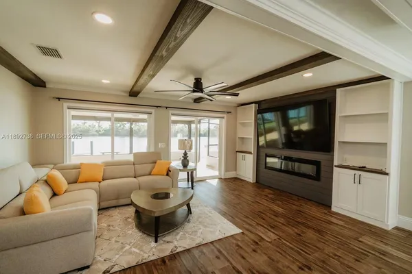 a living room with furniture a flat screen tv and a large window