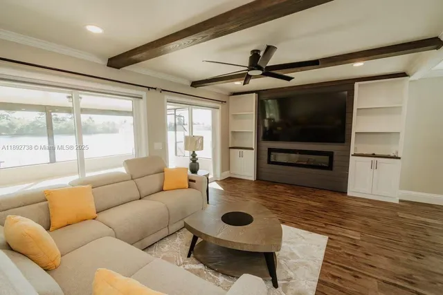 a living room with furniture a flat screen tv and a large window