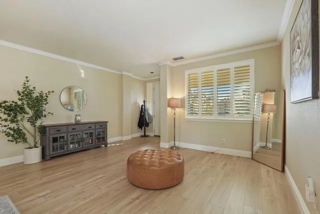 a living room with furniture and a dining table with wooden floor