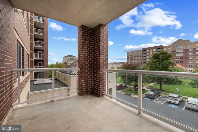 a picture of a room with a white bed and a refrigerator