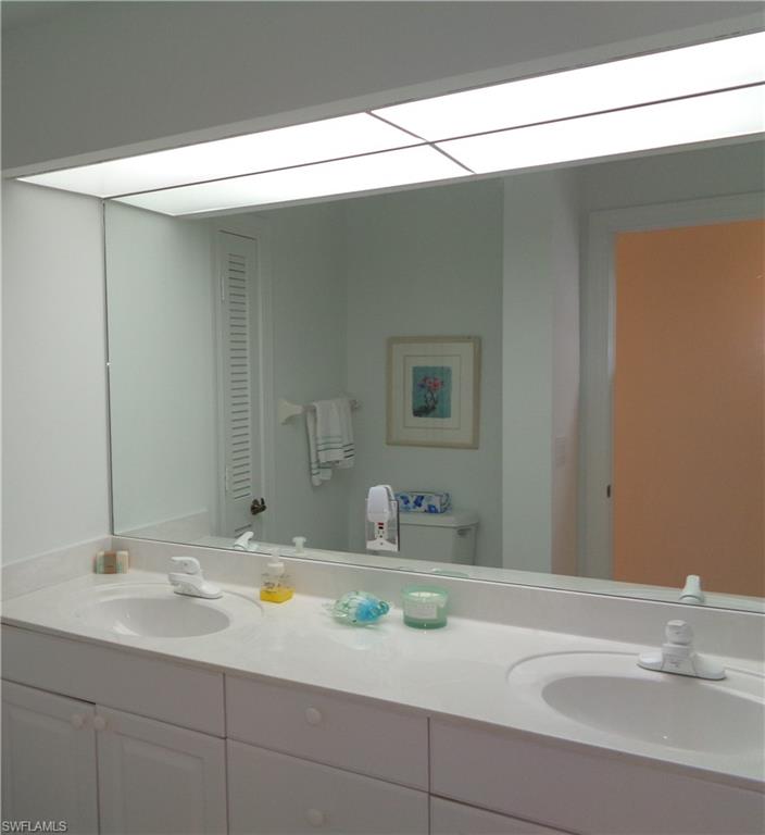 515 Laguna Royale Boulevard, Unit 102 Naples, FL 34119 - Photo 16 of 28 Bathroom featuring double vanity, a sink, and toilet