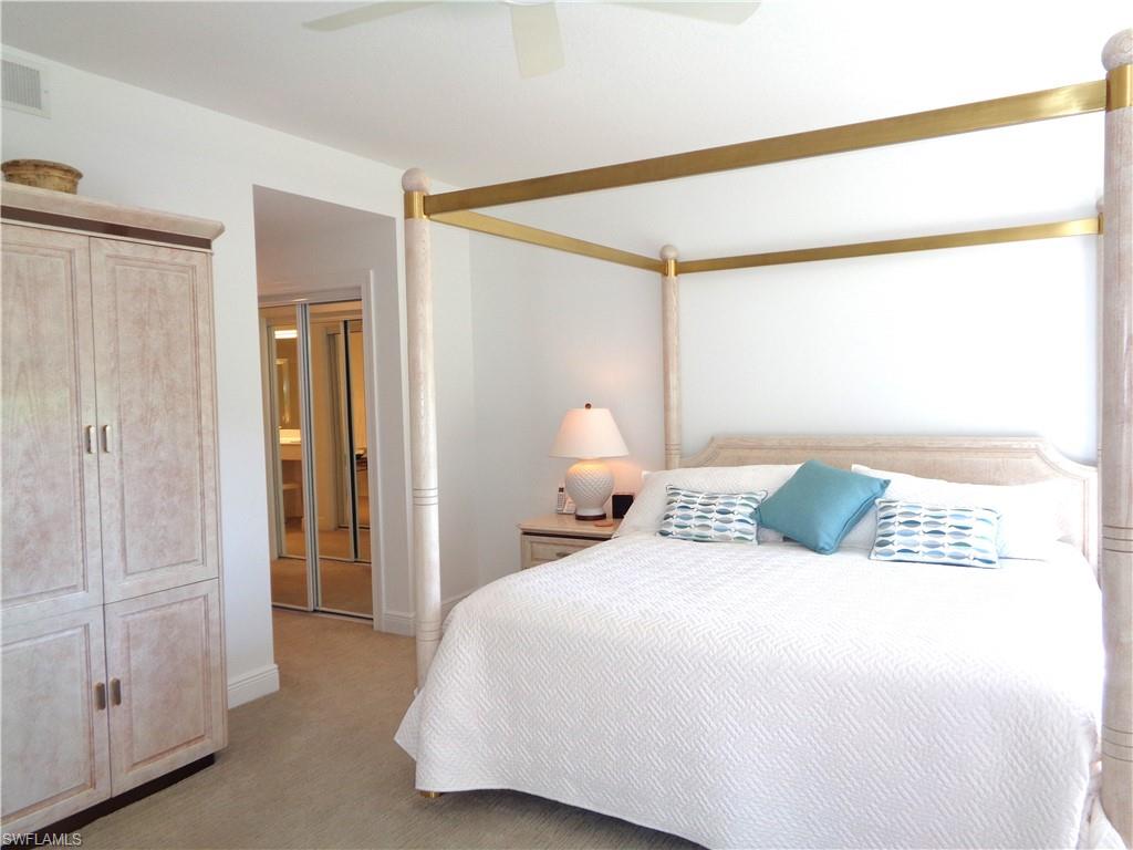 515 Laguna Royale Boulevard, Unit 102 Naples, FL 34119 - Photo 19 of 28 Bedroom with light colored carpet, visible vents, and ceiling fan