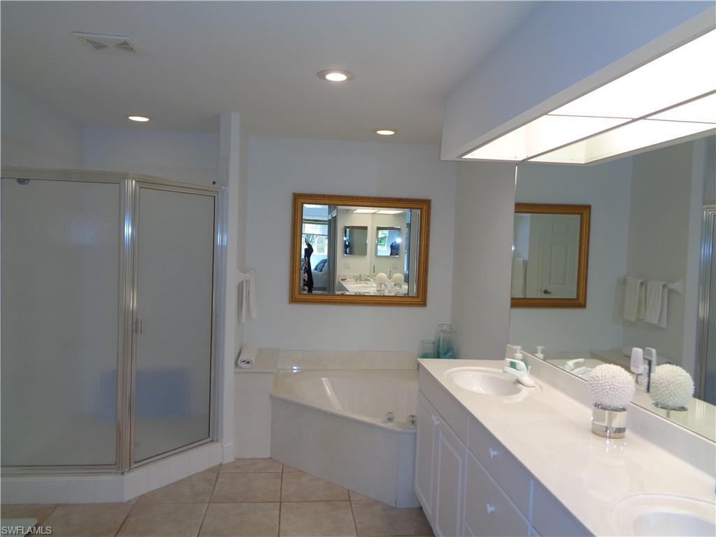 515 Laguna Royale Boulevard, Unit 102 Naples, FL 34119 - Photo 21 of 28 Bathroom featuring tile patterned floors, a sink, a stall shower, and visible vents
