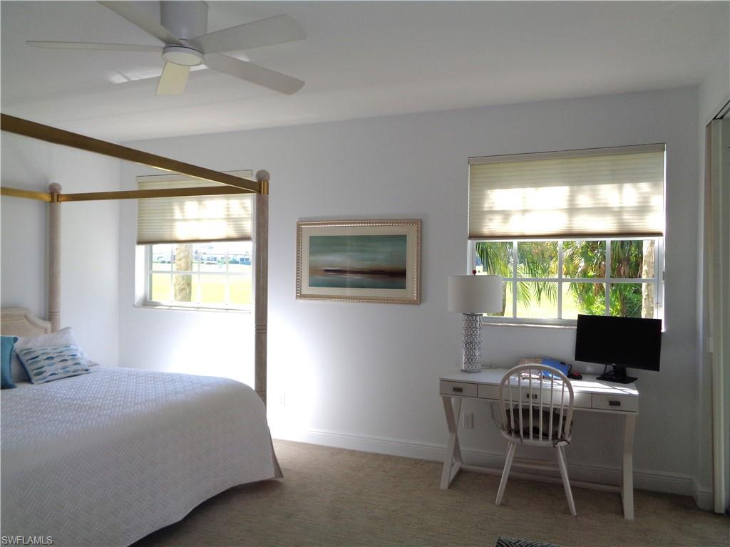 515 Laguna Royale Boulevard, Unit 102 Naples, FL 34119 - Photo 24 of 28 Carpeted bedroom featuring multiple windows, ceiling fan, and baseboards