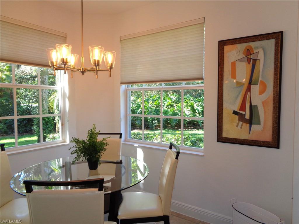 515 Laguna Royale Boulevard, Unit 102 Naples, FL 34119 - Photo 8 of 28 Dining area with baseboards and a notable chandelier