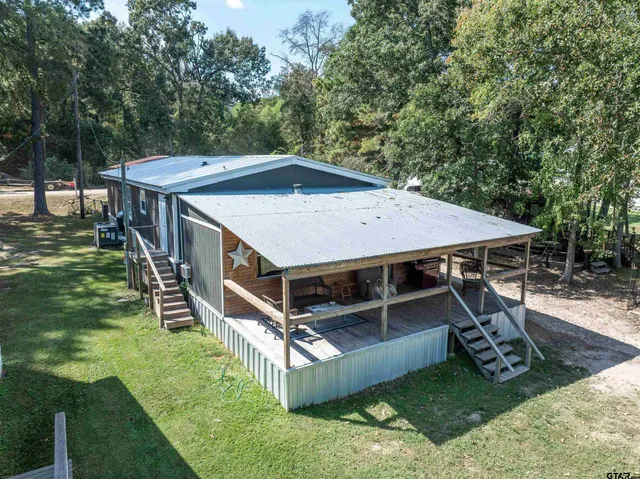 a view of a deck with a big yard and large trees