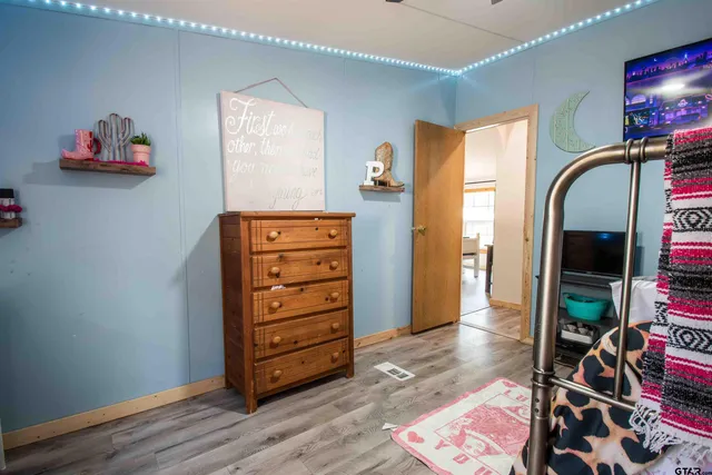 a bedroom with a bed a chandelier and a large window