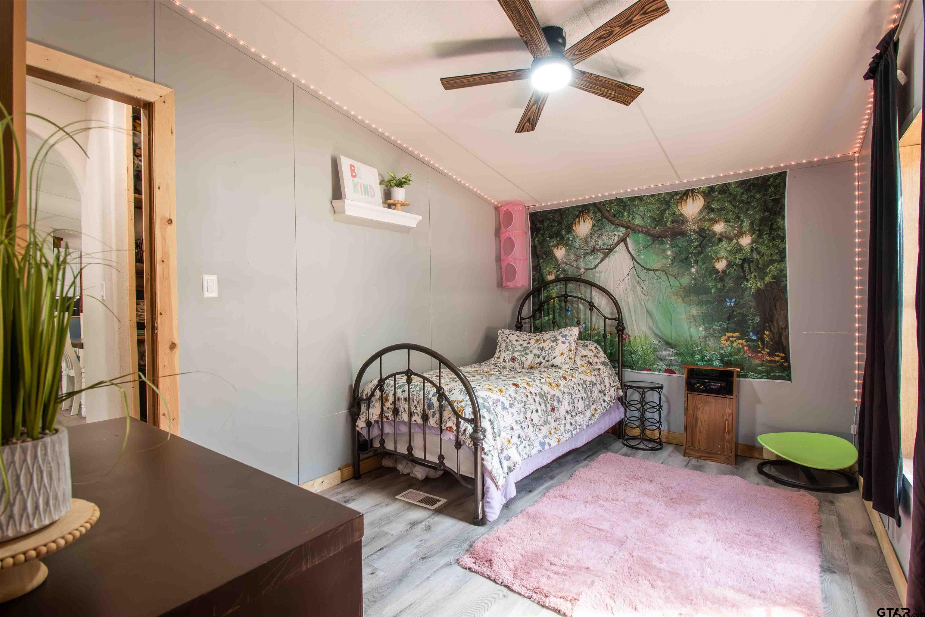 682 Dogwood Trail Murchison, TX 75778 - Photo 26 of 48 a bedroom with a bed a chandelier and a large window