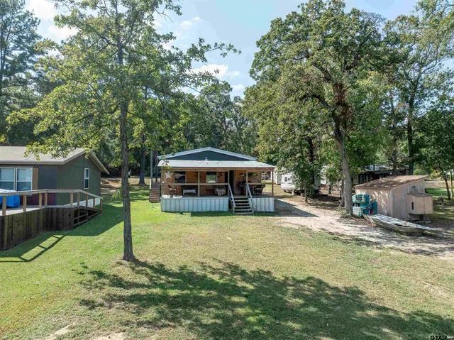 a view of a house with a yard patio and fire pit