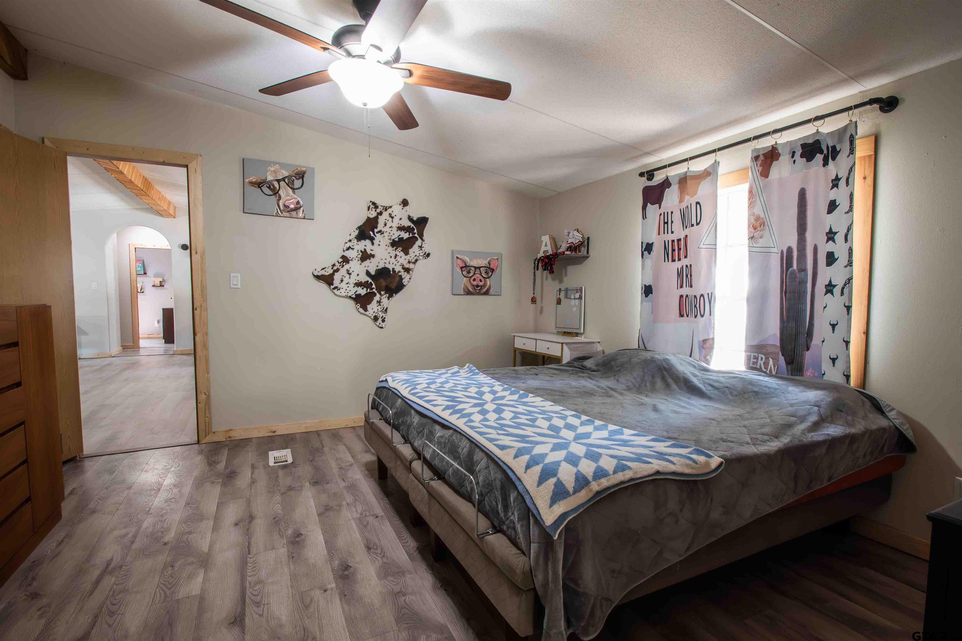 682 Dogwood Trail Murchison, TX 75778 - Photo 34 of 48 a bedroom with a bed and a chandelier