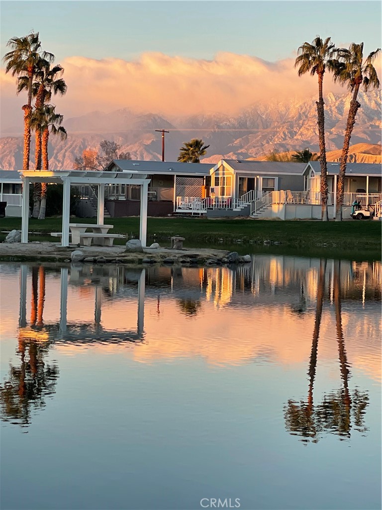 74711 Dillon Road, Unit 69 Desert Hot Springs, CA 92241 - Photo 18 of 18 a view of a lake with a house in the background