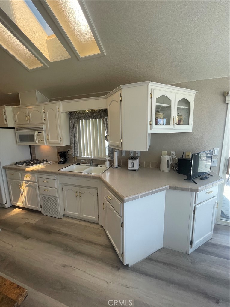 74711 Dillon Road, Unit 69 Desert Hot Springs, CA 92241 - Photo 3 of 18 a kitchen with stainless steel appliances granite countertop a stove a sink and white cabinets