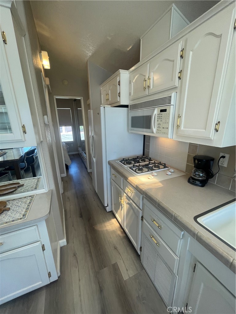 74711 Dillon Road, Unit 69 Desert Hot Springs, CA 92241 - Photo 7 of 18 a kitchen with a stove and a white cabinets