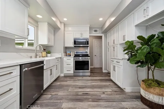 a kitchen with kitchen island a counter top space appliances and cabinets