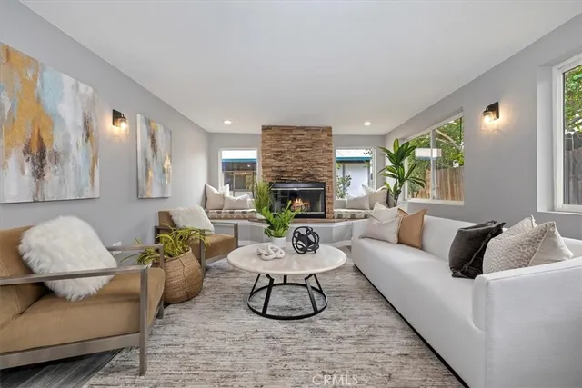 a living room with furniture a fireplace and a large mirror next to a window