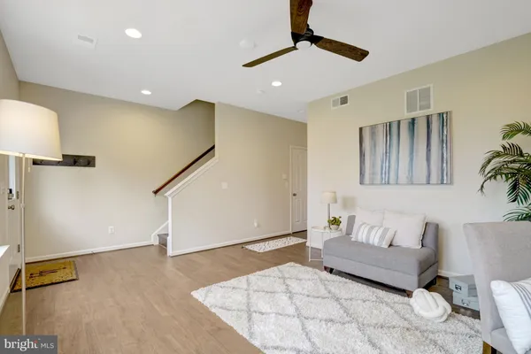 a living room with furniture and a ceiling fan
