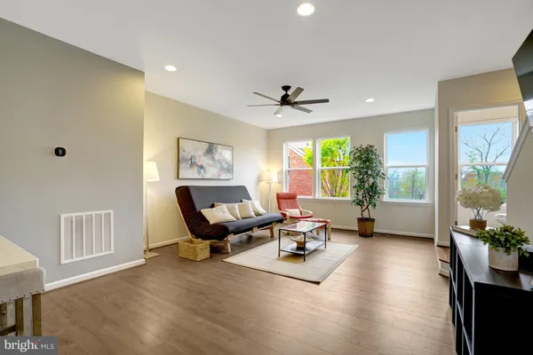 a living room with furniture floor to ceiling window and a wooden floor