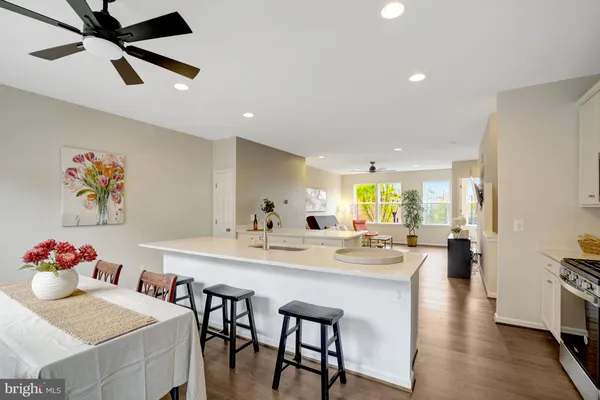 a kitchen with a dining table chairs wooden floor and appliances
