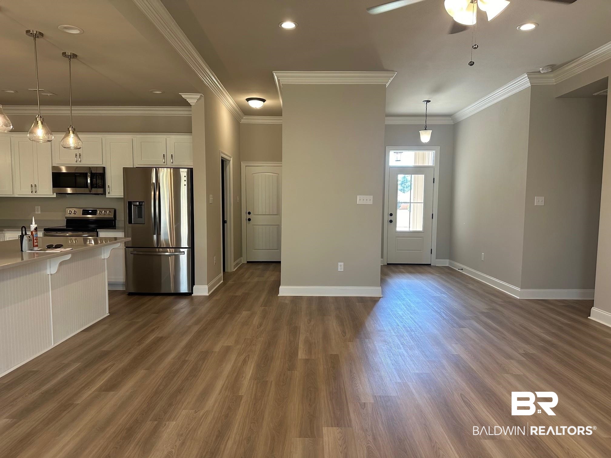 1009 Ruisseau Drive Foley, AL 36535 - Photo 36 of 55 Kitchen with appliances with stainless steel finishes, white cabinets, decorative light fixtures, and dark wood-type flooring