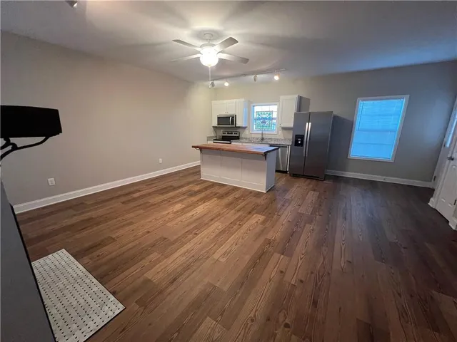 a view of kitchen with cabinets appliances and wooden floor