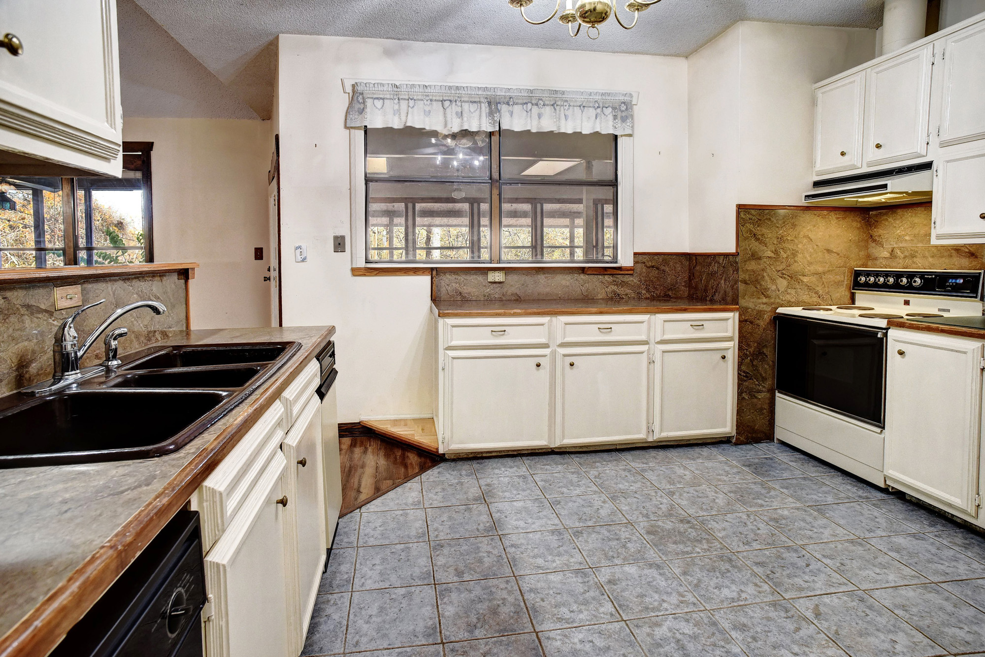 113 My Road Bastrop, TX 78602 - Photo 15 of 35 Kitchen with tasteful backsplash, white electric range, white cabinets, a textured ceiling, and under cabinet range hood