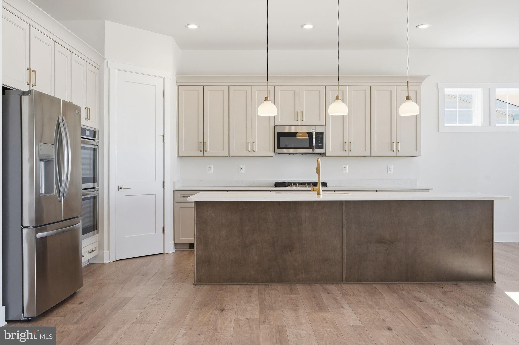 124 Bridge Valley Road Gettysburg, PA 17325 - Photo 15 of 34 a kitchen with kitchen island granite countertop a refrigerator a sink and white cabinets
