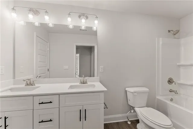 a bathroom with a toilet a sink a tub and mirror