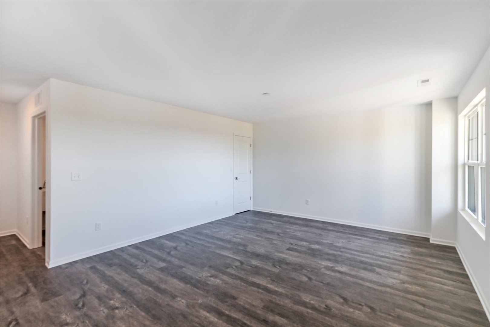 542 Comstock Road South Elgin, IL 60177 - Photo 6 of 32 a view of an empty room with wooden floor and a window
