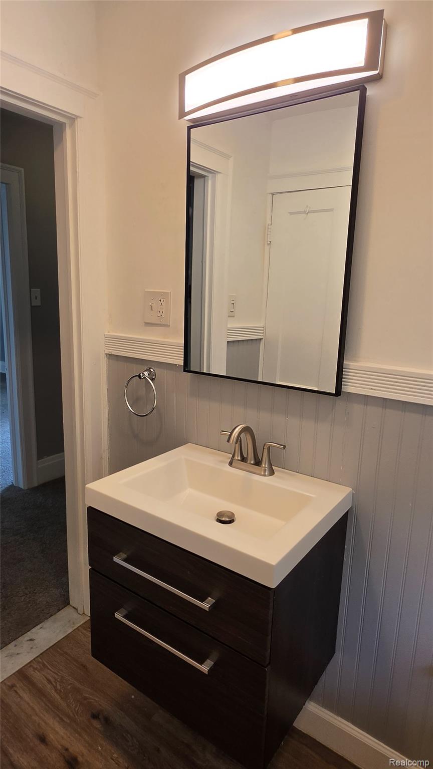 16715 Edinborough Road Detroit, MI 48219 - Photo 13 of 21 Floating vanity with integrated basin, brushed nickel faucet, wall-mounted mirror, and overhead light fixture