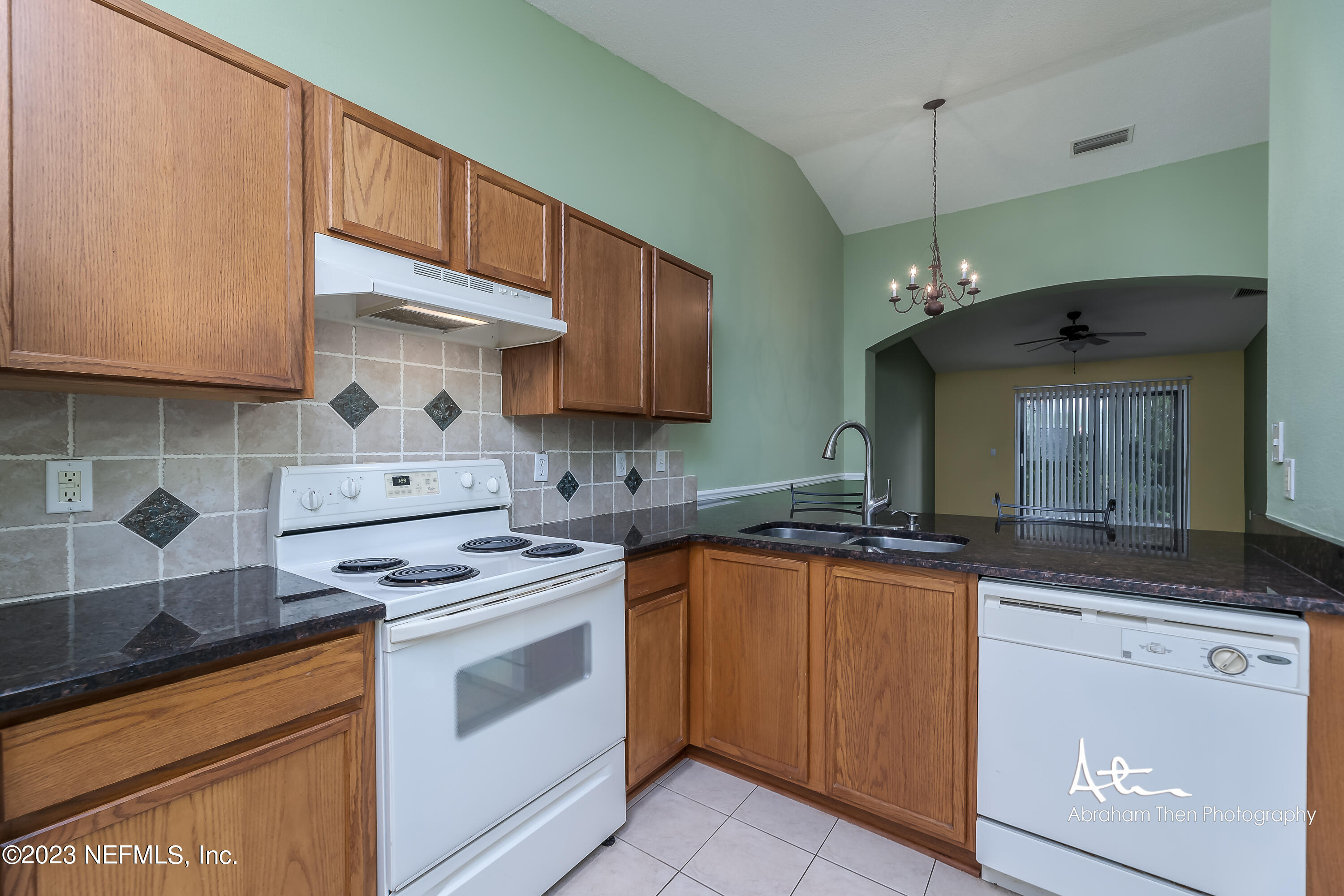 742 Ginger Mill Drive St. Johns, FL 32259 - Photo 7 of 32 a kitchen with granite countertop a sink stove and cabinets
