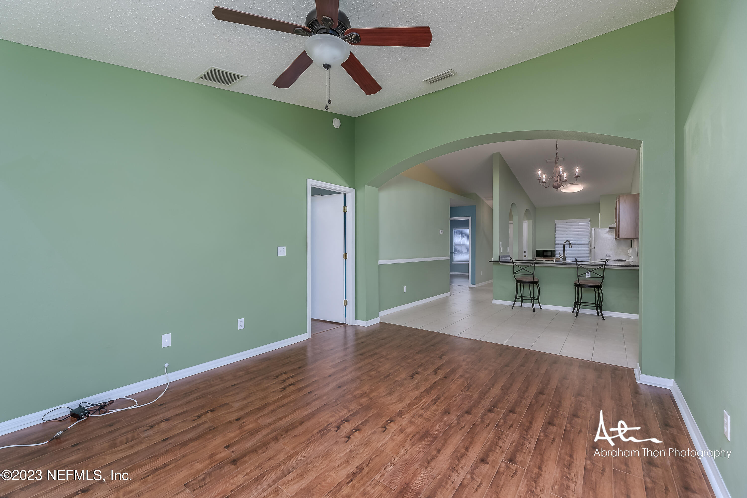 742 Ginger Mill Drive St. Johns, FL 32259 - Photo 10 of 32 a view of a room with wooden floor a ceiling fan and a kitchen
