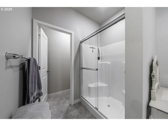 a bathroom with a glass shower door and a mirror