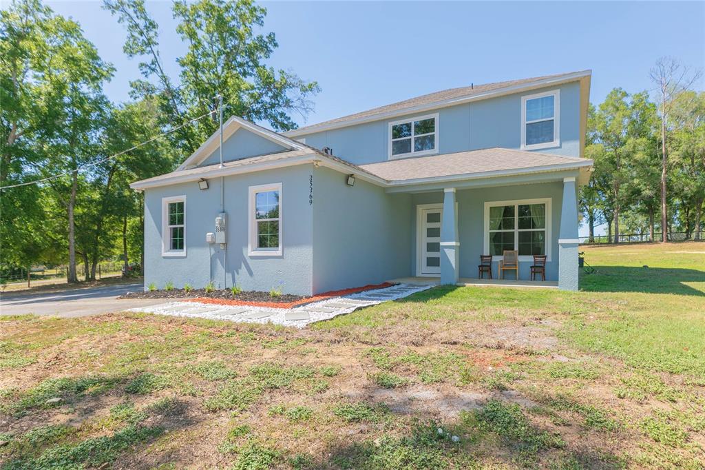 35369 Ruffing Road Dade City, FL 33523 - Photo 2 of 63 a view of a yard in front of a house with large windows