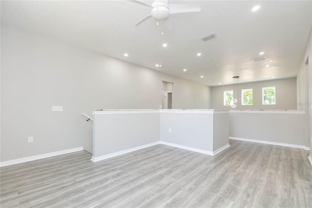 35369 Ruffing Road Dade City, FL 33523 - Photo 24 of 63 a view of an empty room with wooden floor and a kitchen