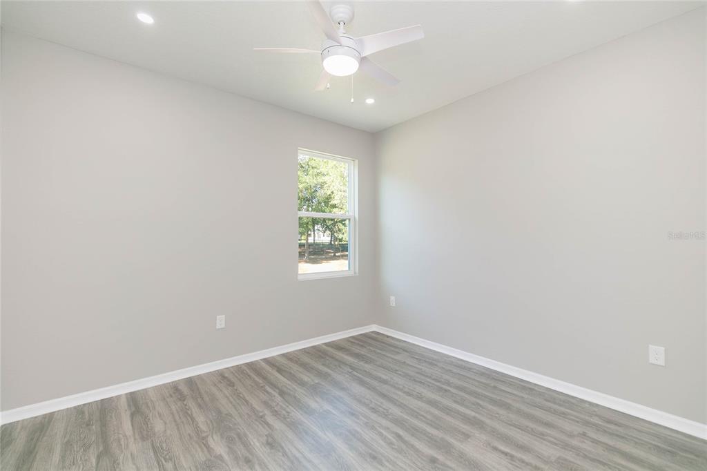 35369 Ruffing Road Dade City, FL 33523 - Photo 32 of 63 an empty room with wooden floor and windows