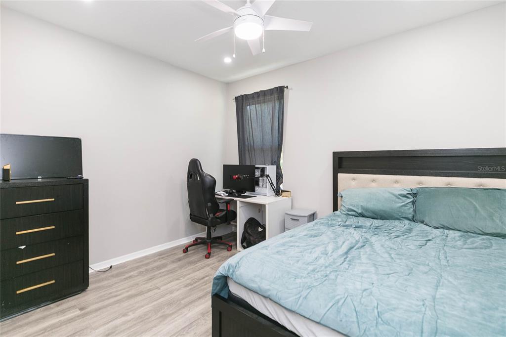 35369 Ruffing Road Dade City, FL 33523 - Photo 34 of 63 a bedroom with a bed and a chandelier