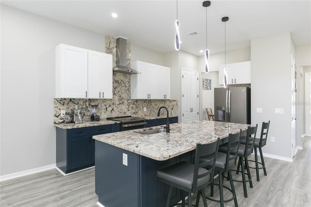 35369 Ruffing Road Dade City, FL 33523 - Photo 4 of 63 a kitchen with stainless steel appliances granite countertop a kitchen island a stove a table and chairs
