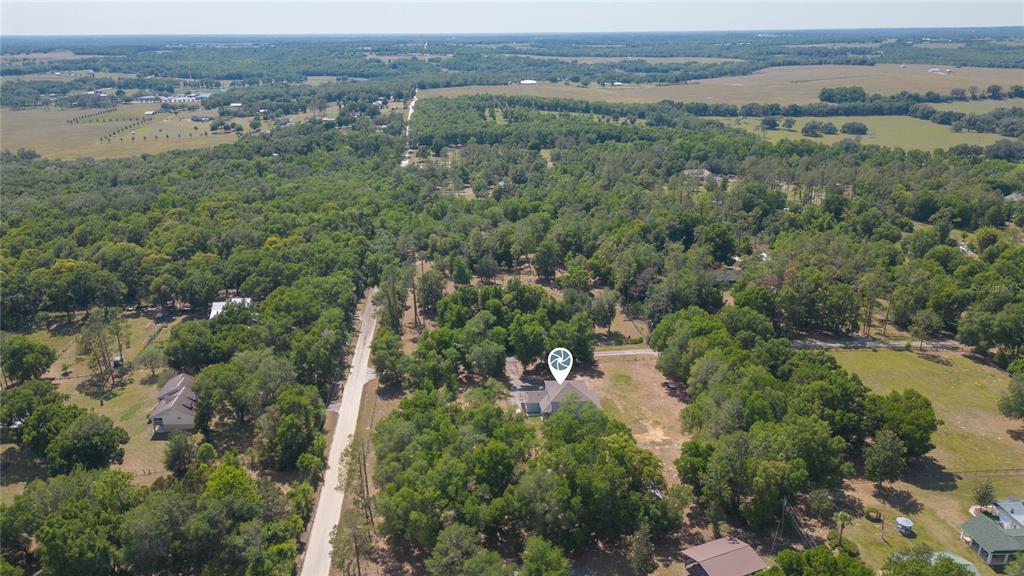 35369 Ruffing Road Dade City, FL 33523 - Photo 54 of 63 an aerial view of green landscape with trees houses and mountain view