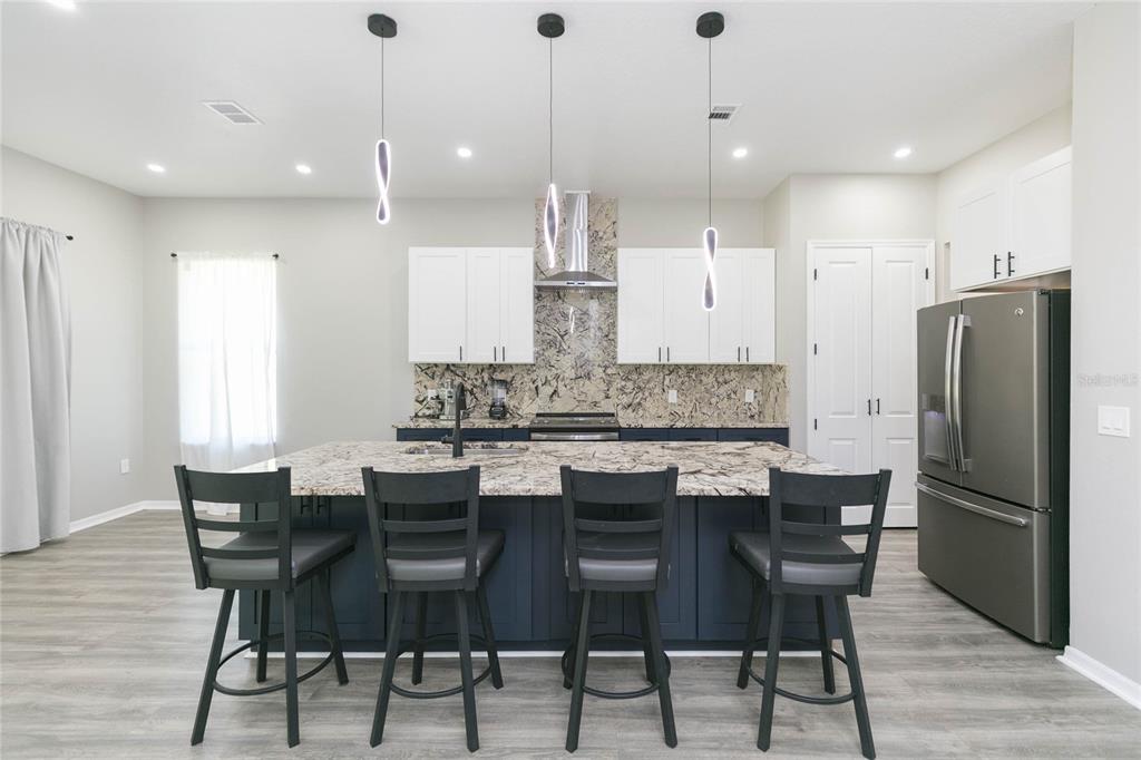 35369 Ruffing Road Dade City, FL 33523 - Photo 10 of 63 a kitchen with stainless steel appliances kitchen island granite countertop a dining table chairs and white cabinets