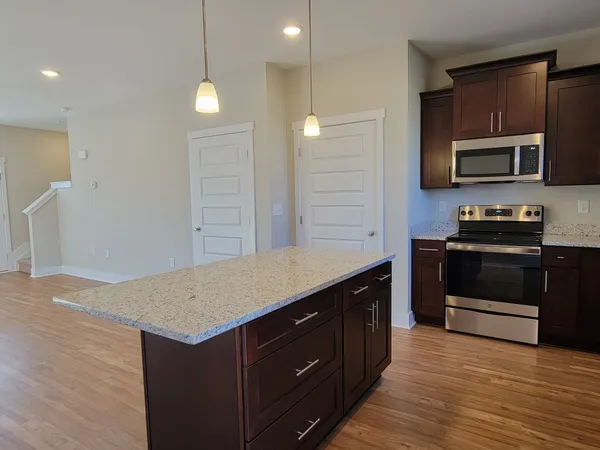 a kitchen with stainless steel appliances granite countertop a stove a sink and a microwave