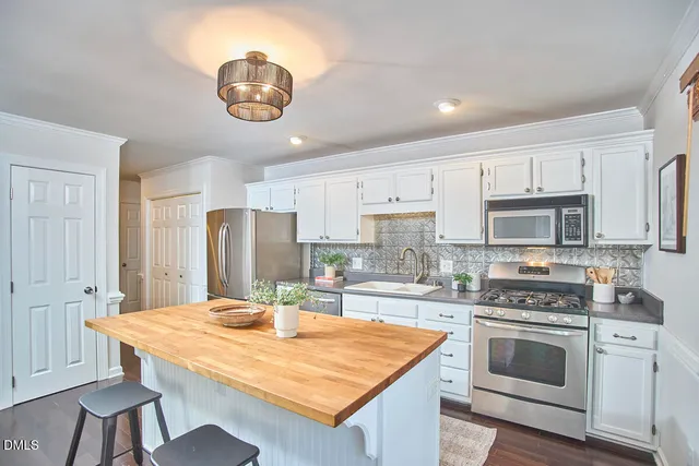 a kitchen with stainless steel appliances granite countertop a stove refrigerator sink and cabinets