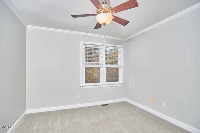 an empty room with a window and a fan