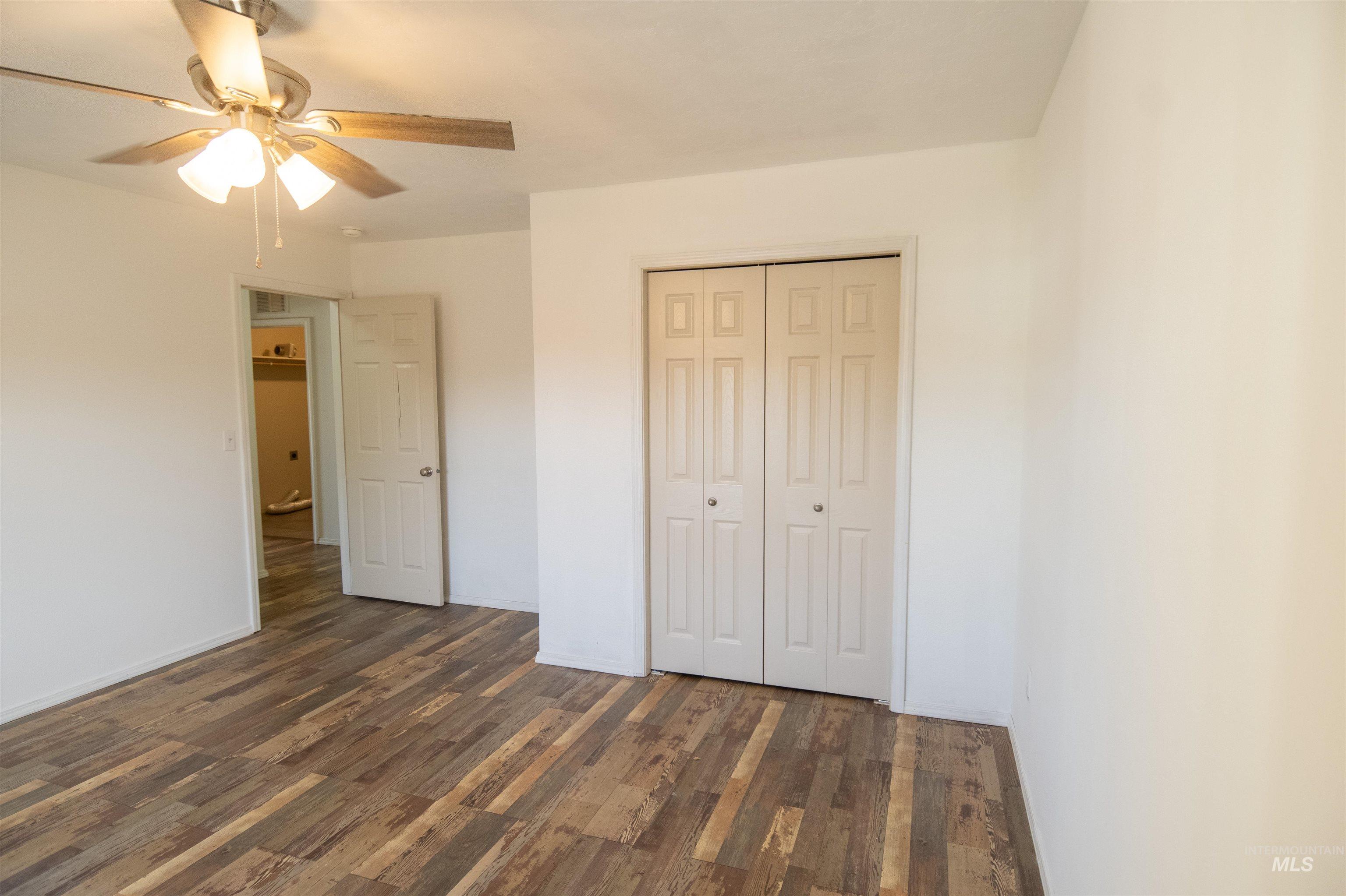 880 Southwest Independence Mountain Home, ID 83647 - Photo 25 of 50 Unfurnished bedroom featuring dark wood-type flooring, a closet, and a ceiling fan
