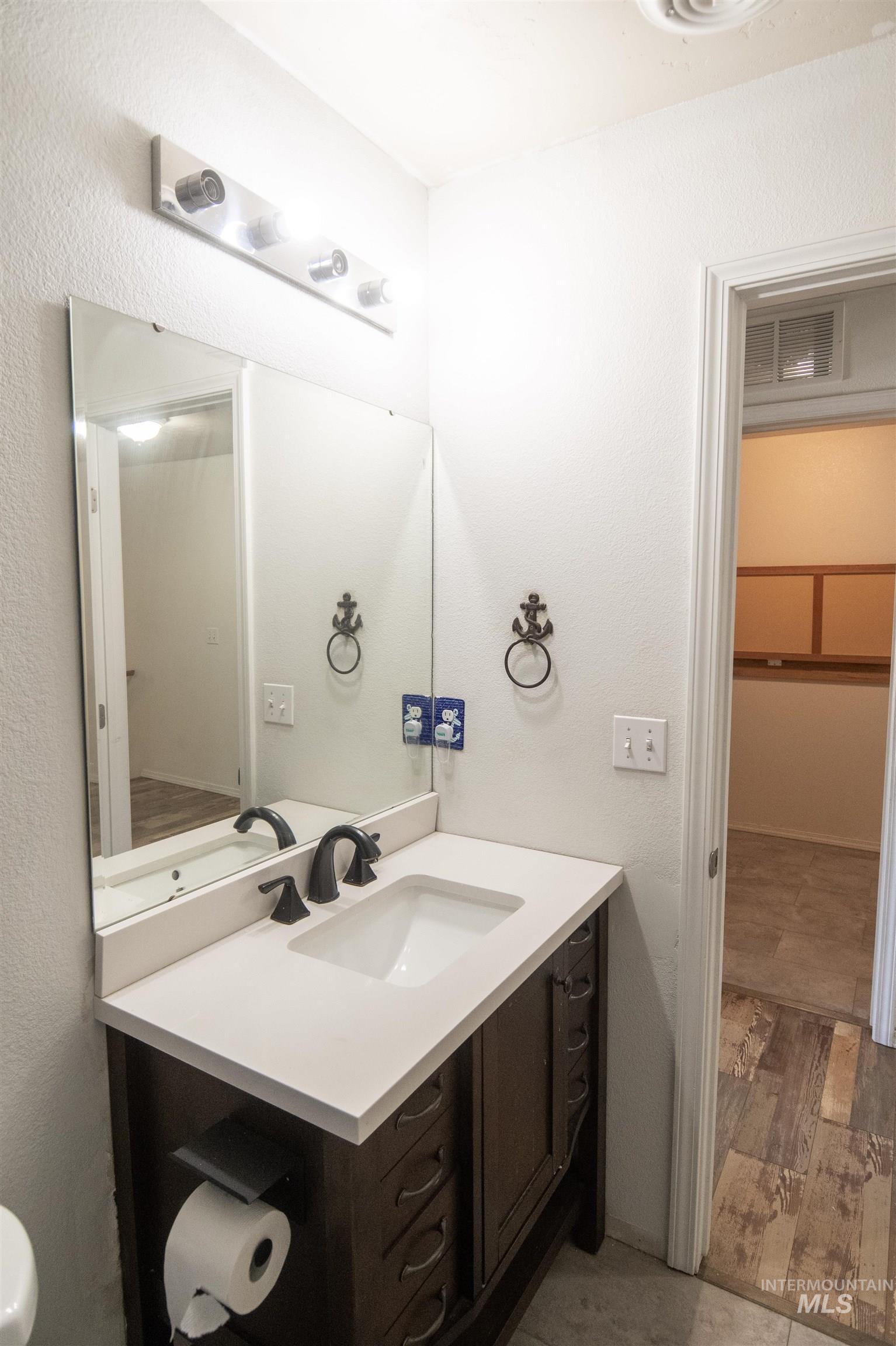 880 Southwest Independence Mountain Home, ID 83647 - Photo 31 of 50 Bathroom featuring light wood-style floors, vanity, and a textured wall