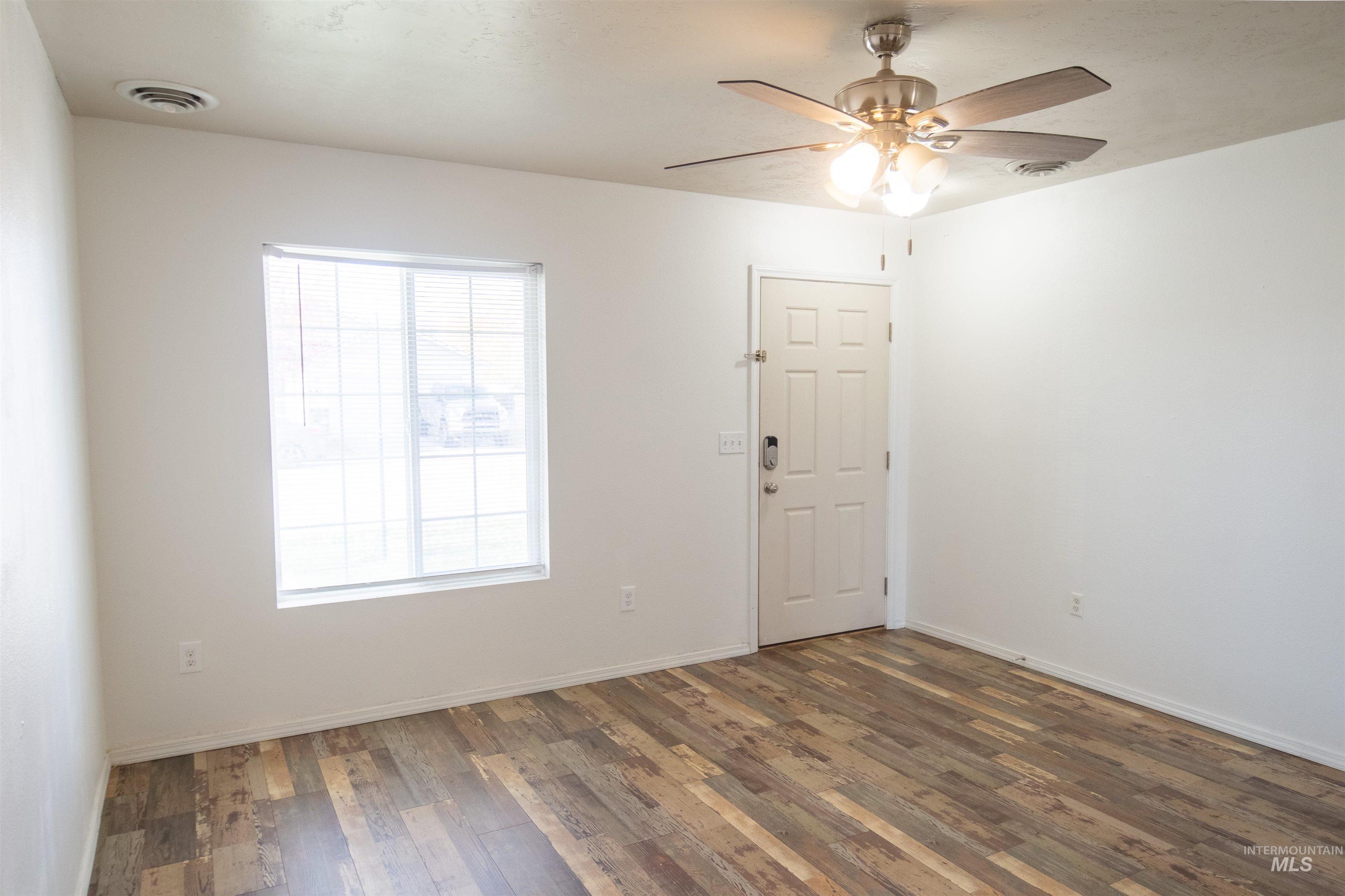 880 Southwest Independence Mountain Home, ID 83647 - Photo 8 of 50 Unfurnished room featuring dark wood-style floors and ceiling fan